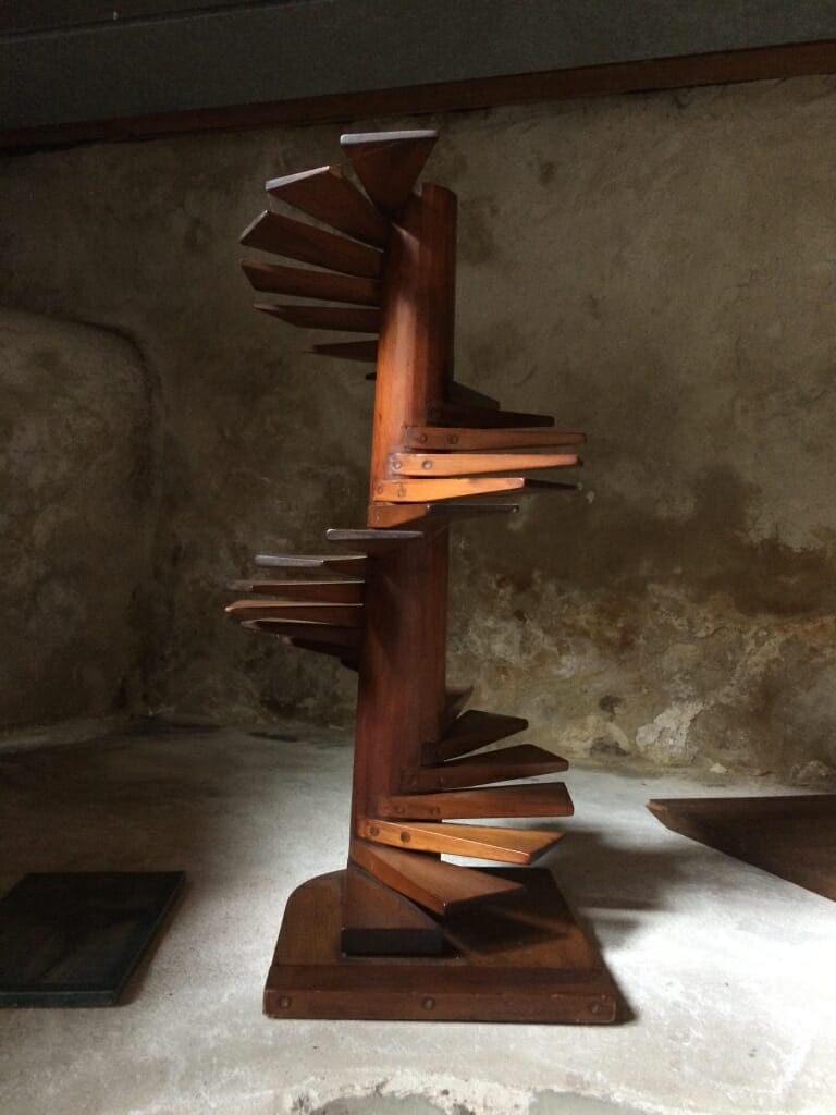 Wood model of spiral staircase with cantilevered steps spiraling up a central post.
