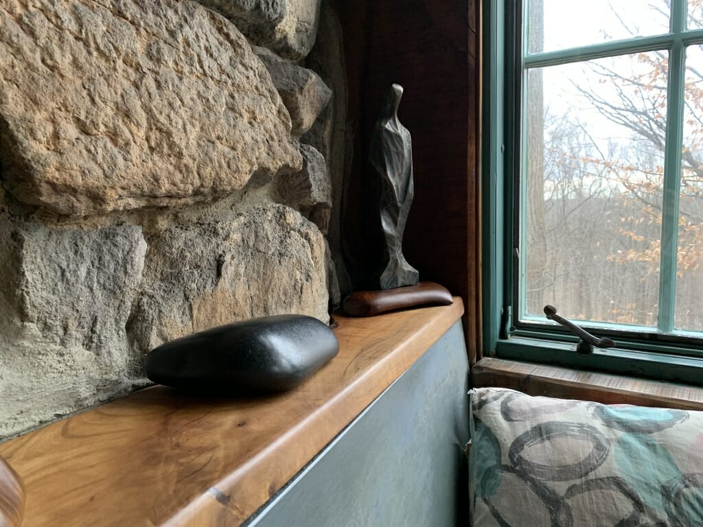 smooth black stone sits on the shelf behind bench