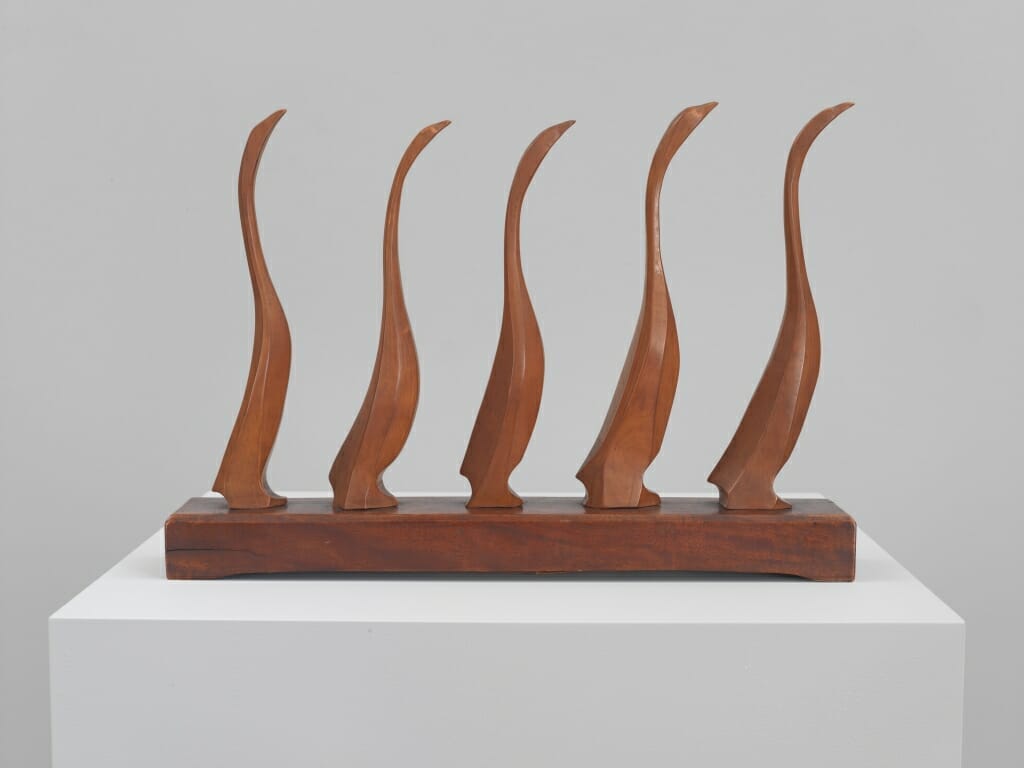 wood sculpture of five goslings in a line