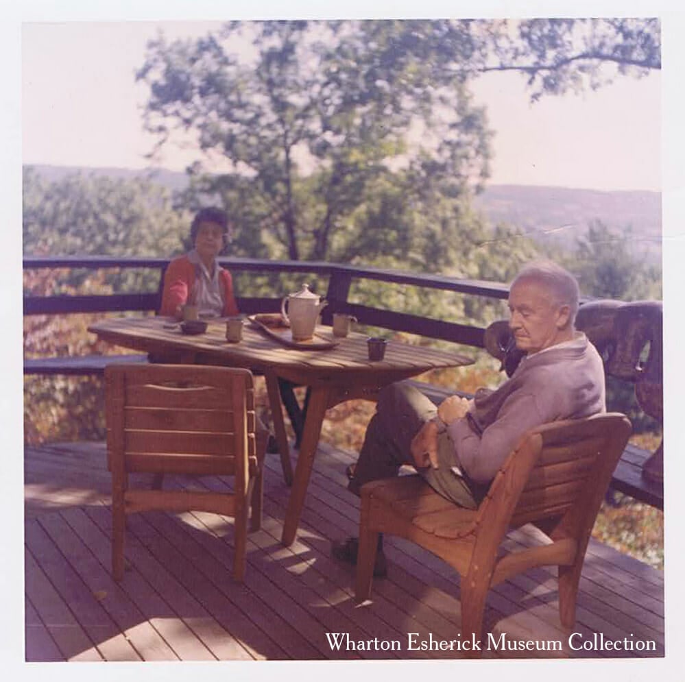 Elderly man and woman sitting on wood deck overlooking woods