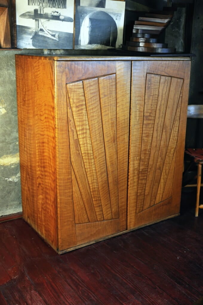 wood cabinet with doors with boards laid out in a fanning design on the front