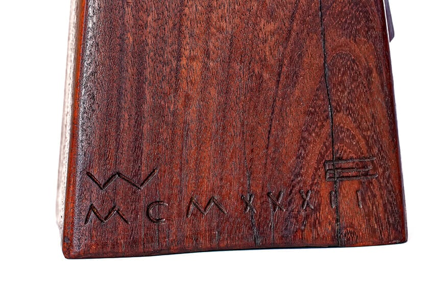 detail of wood base with carved initials and roman numeral date