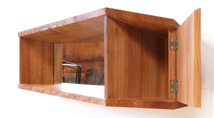 rectangular wood wall shelf and cabinet with prismatic angles and mirror behind shelf