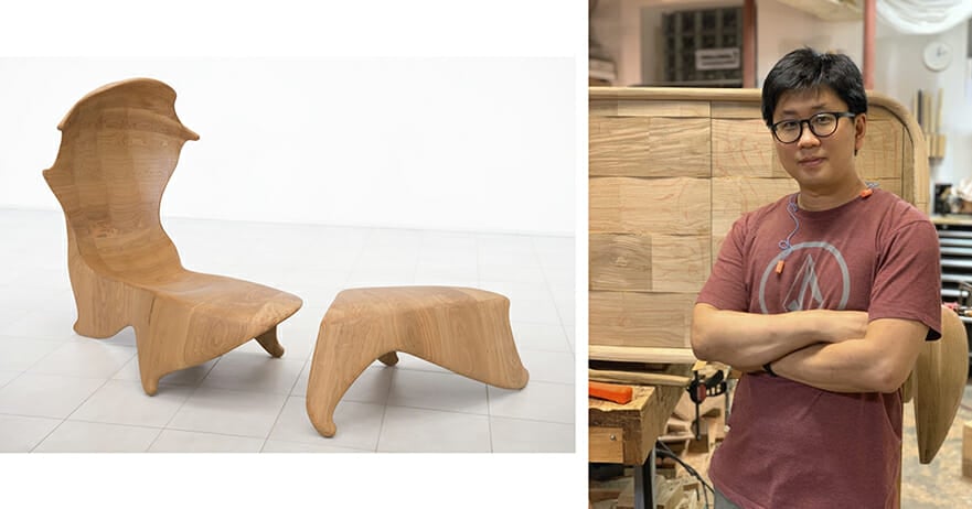 On the left we seen a wooden organic chair formwith a high curving back and a footstool. On the right we see a man with his arms folded acroos his chest wearing a faded red t-shirt and standing in a woodshop.