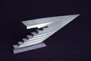 aluminum cast sculpture of an abstract pointed arrow form with step-like facets on the bottom