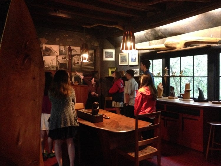 a tour guide point to a photograph inside the Esherick Studio, surrounded by students