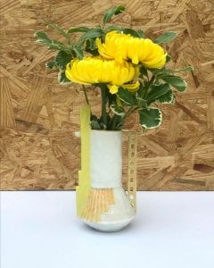 small vase with painted orange lines, tall yellow "chimney" and ladder-like handle