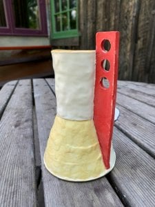 small vessel with yellow base and interior with red flange with three holes
