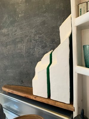 two abstract white sculptures on a wood shelf in esherick's kitchen. There is a sliver of green seen between the two forms.