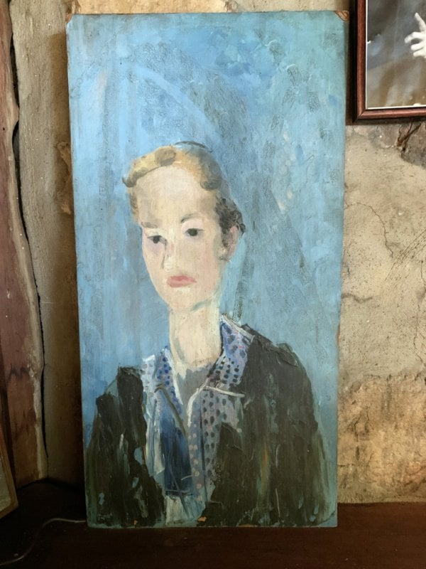 painting of woman with hair tied back and blue background leans on stone wall
