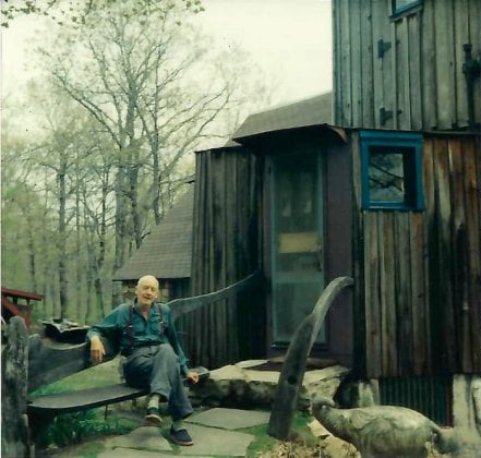Photo of Esherick sitting in front of his studio