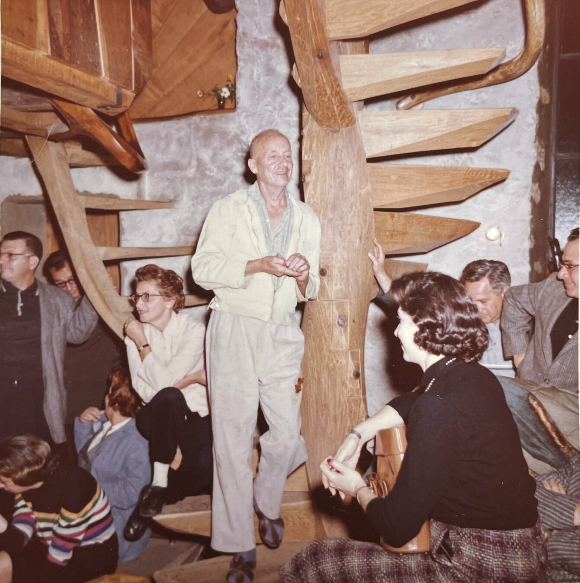 Wharton Esherick standing on spiral staircase during a party he held at the Studio